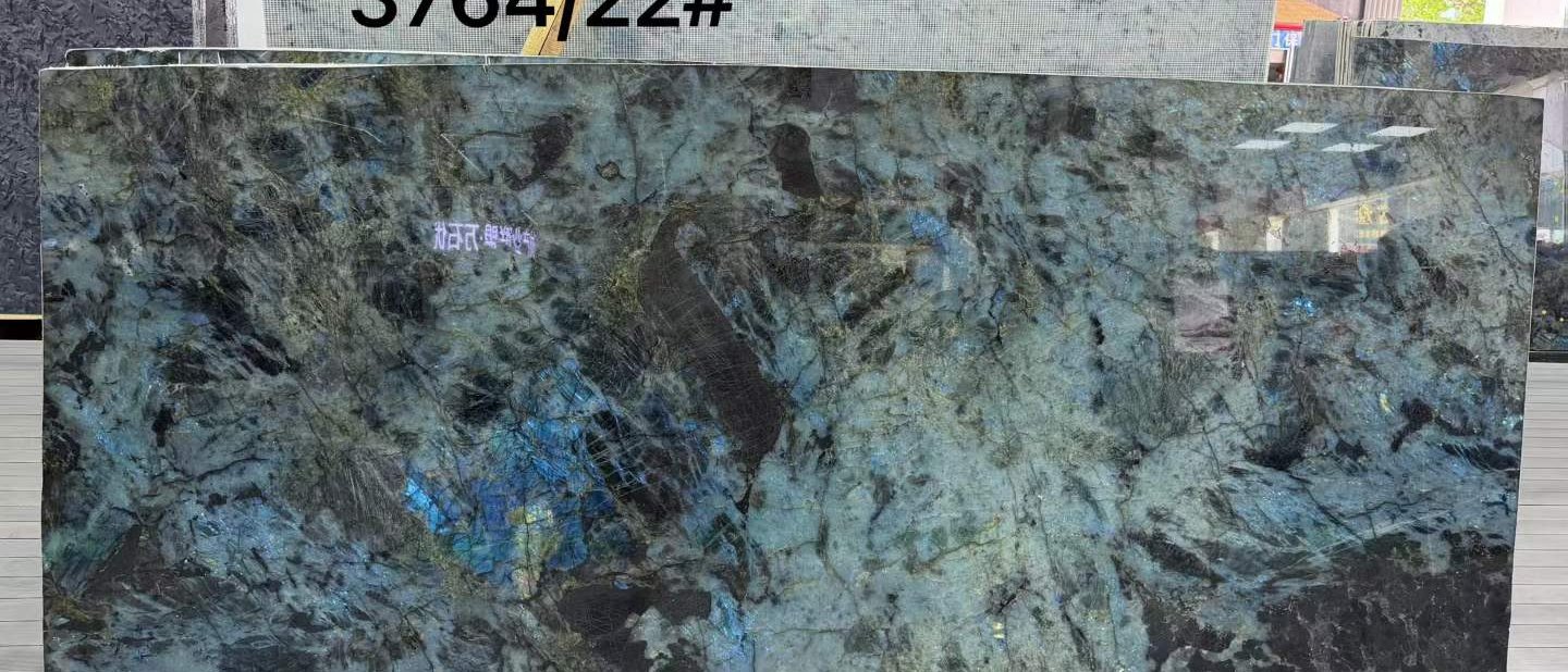 Polished Labradorite Blue slab with iridescent blue and teal flashes on a dark crystalline ground